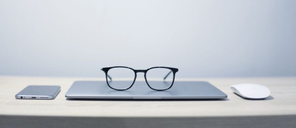 Picture of phone, laptop, mouse and reading glasses