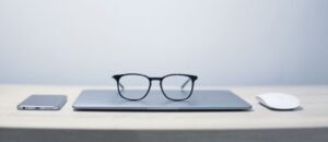 Picture of phone, laptop, mouse and reading glasses
